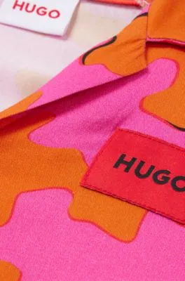 Camisa para niños con estampado llamativo y etiqueta con logo roja