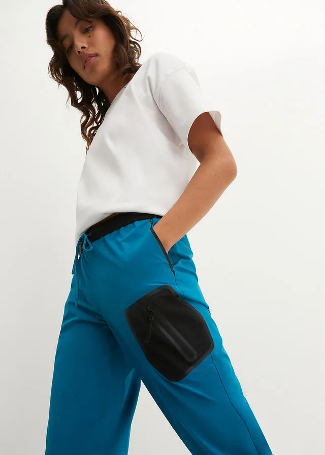 Pantalón elástico en 4 direcciones con material impermeable y bolsillos turquesa profundo